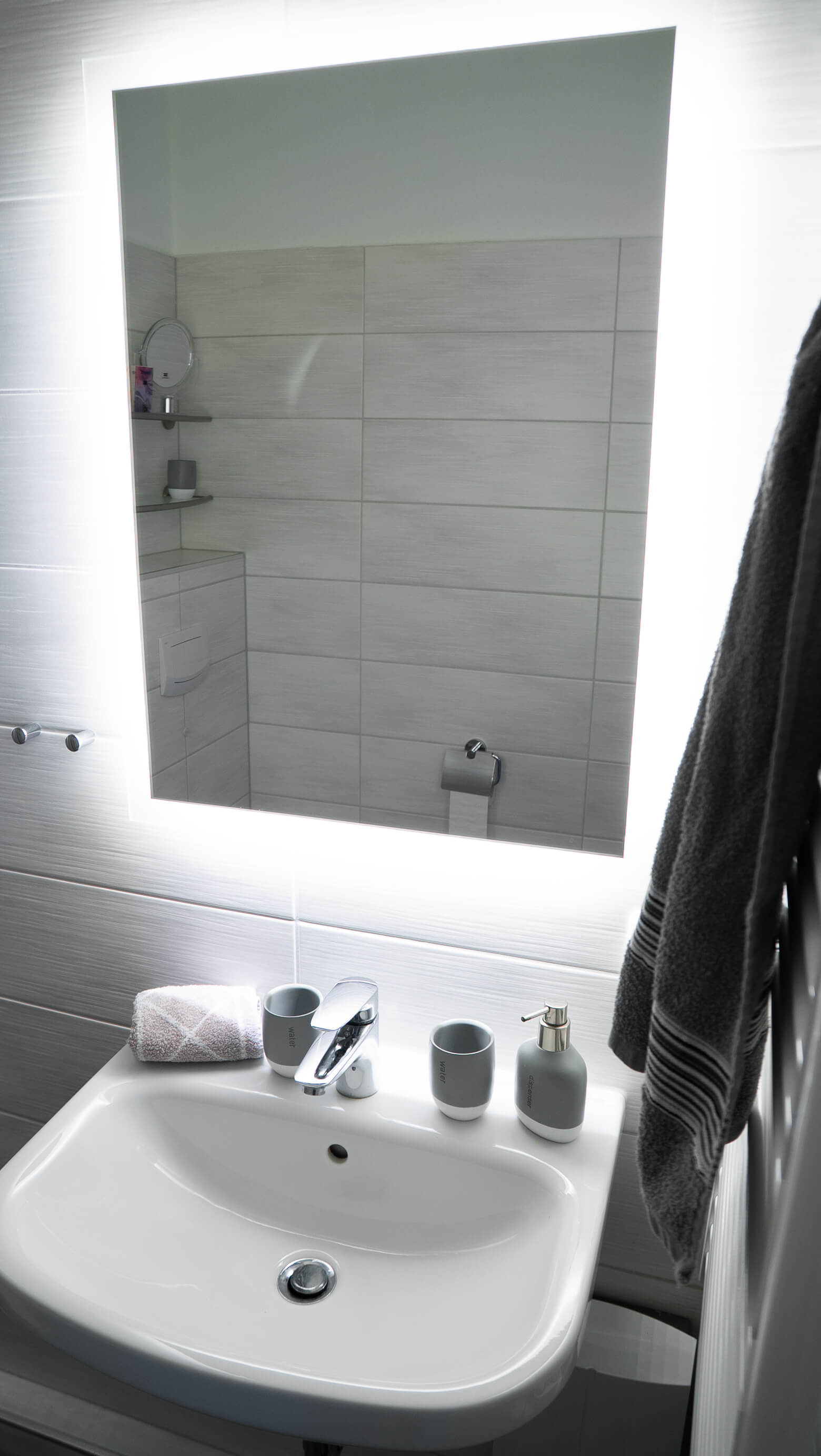 Der Spiegel und das Waschbecken im Badezimmer.