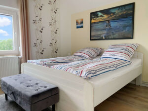 Ein Doppelbett im hellen Schlafzimmer.