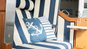 Strandkorb mit Weinglas und Buch auf dem Tisch.