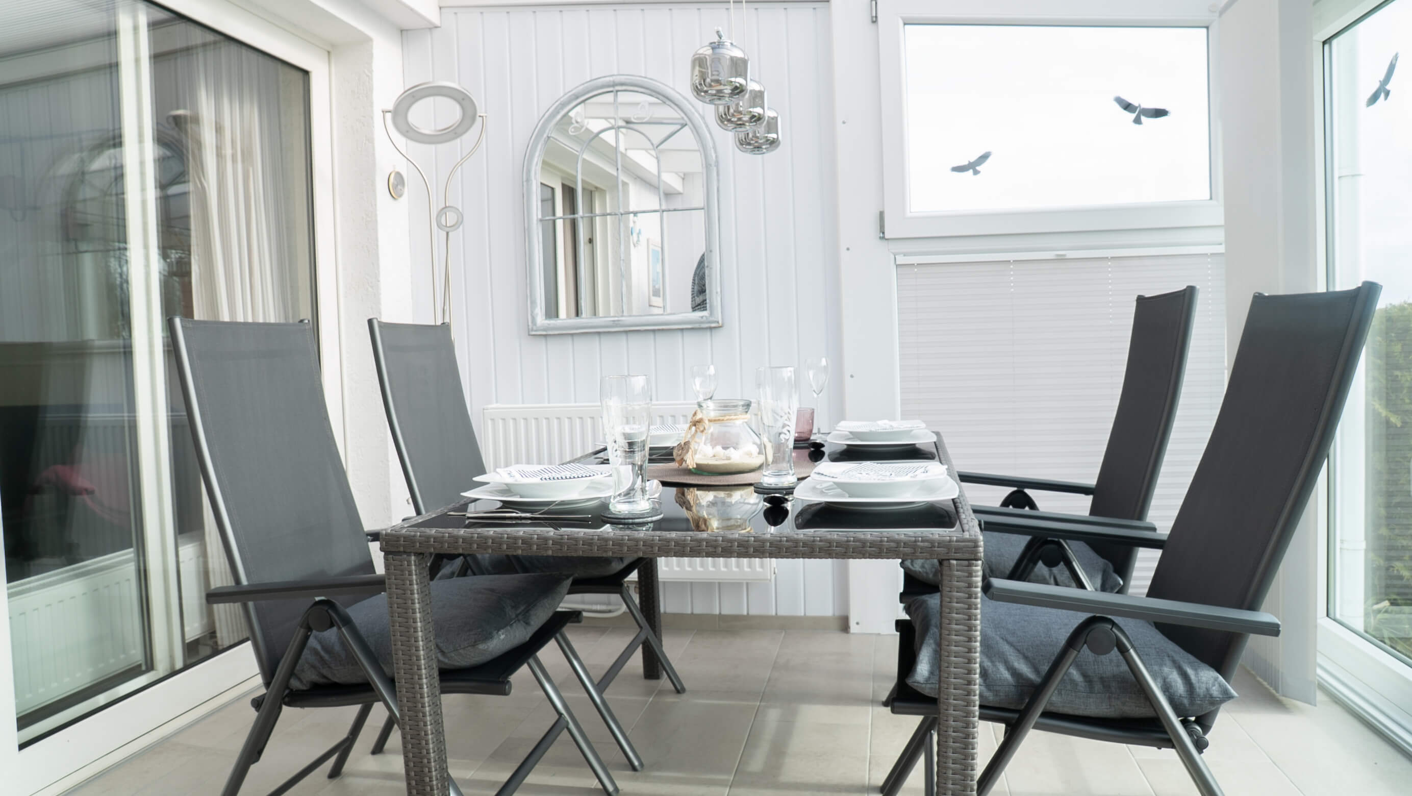 Ein gedeckter Esstisch im Wintergarten.